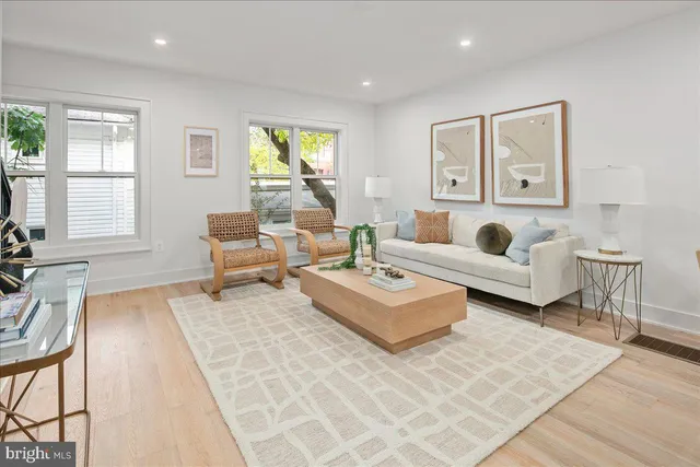 a living room with furniture a wooden floor and a chandelier