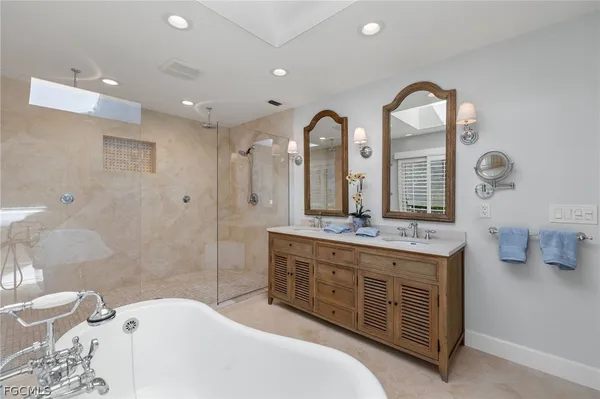 a spacious bathroom with a granite countertop tub a double vanity sink and a mirror
