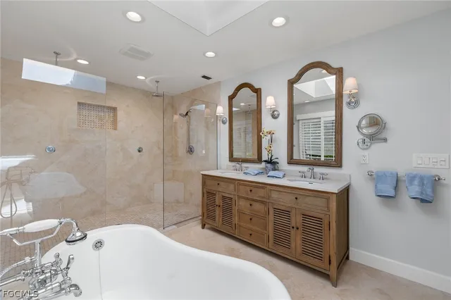 a spacious bathroom with a granite countertop tub a double vanity sink and a mirror