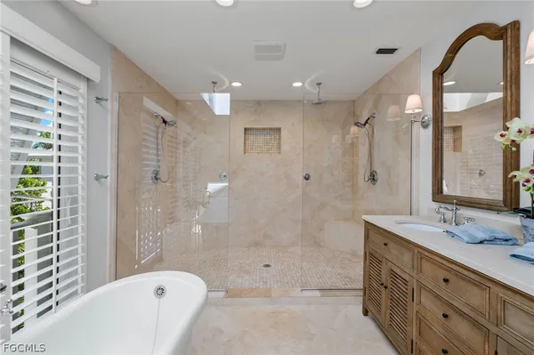 a bathroom with a bathtub shower sink and mirror