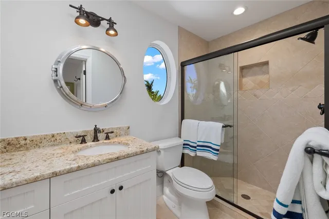 a bathroom with a granite countertop toilet sink and mirror