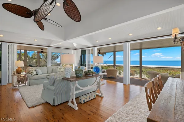 a living room with furniture ceiling fan and a large window