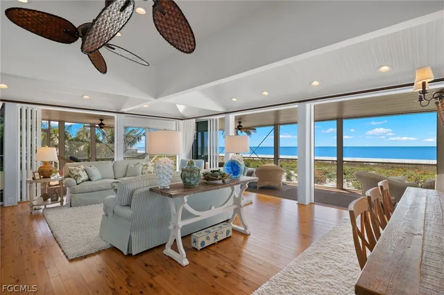a living room with furniture ceiling fan and a large window