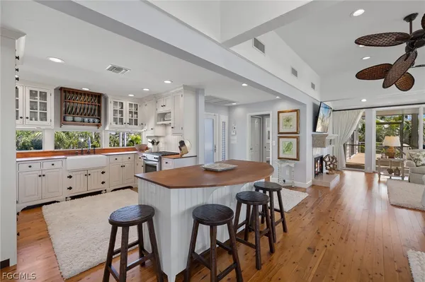 a kitchen with stainless steel appliances kitchen island granite countertop a table chairs and a refrigerator