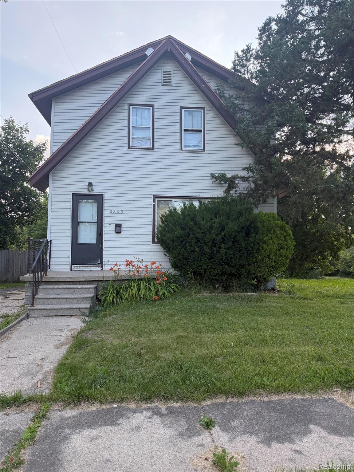 2209 Mason Street Flint, MI 48503 - Photo 1 of 1 Two-story home featuring light-toned siding and a prominent gable roofline with dark trim