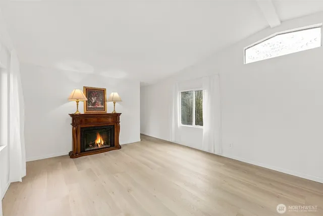 a view of an empty room with a fireplace and a window