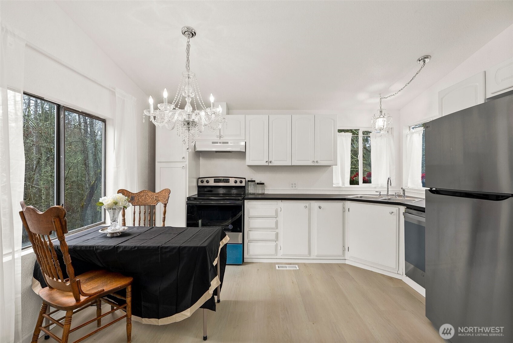 14512 246th Street East Graham, WA 98338 - Photo 5 of 17 a kitchen with stainless steel appliances granite countertop a stove top oven a refrigerator a sink and a dining table with garden view
