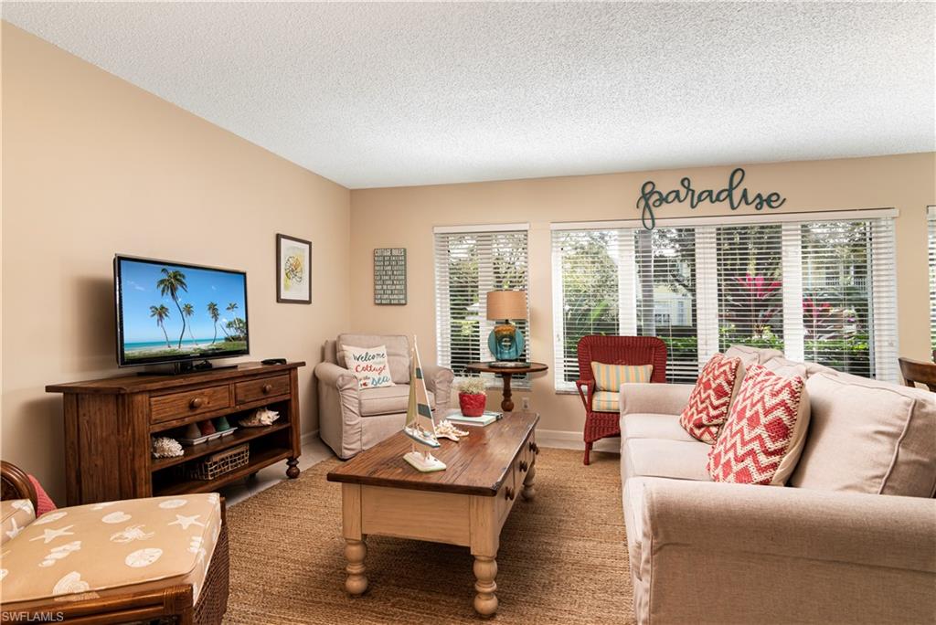 284 4th Street South, Unit 103 Naples, FL 34102 - Photo 3 of 11 a living room with furniture and a flat screen tv
