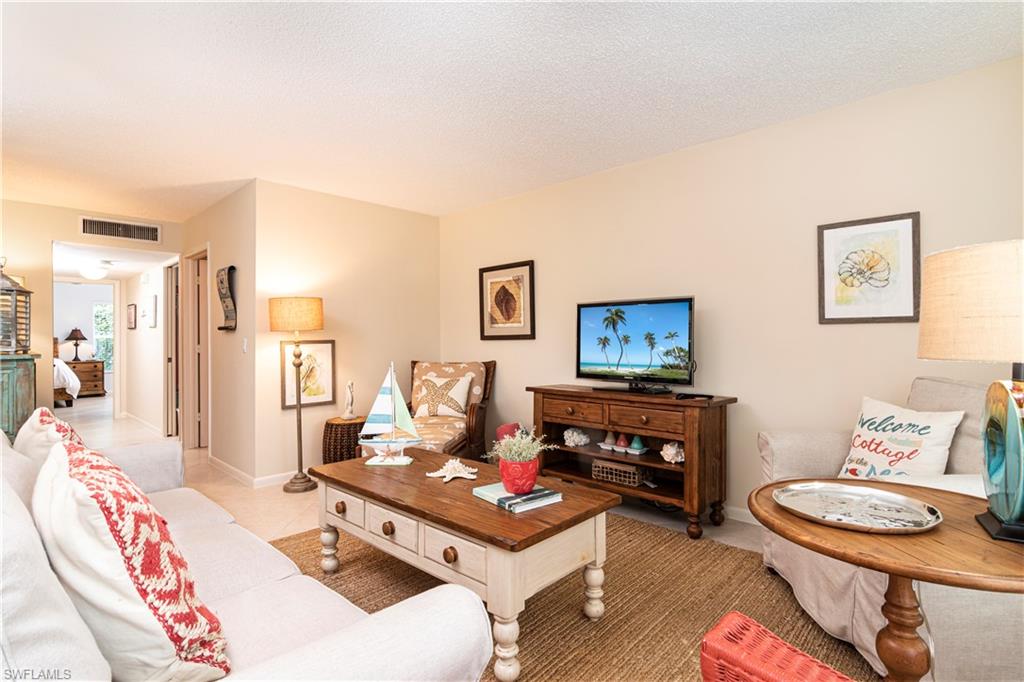 284 4th Street South, Unit 103 Naples, FL 34102 - Photo 4 of 11 a living room with furniture and a table