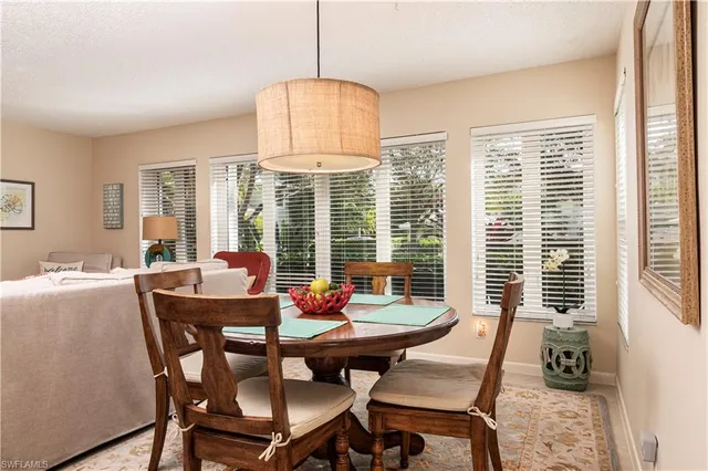 a dining room with furniture a chandelier and wooden floor