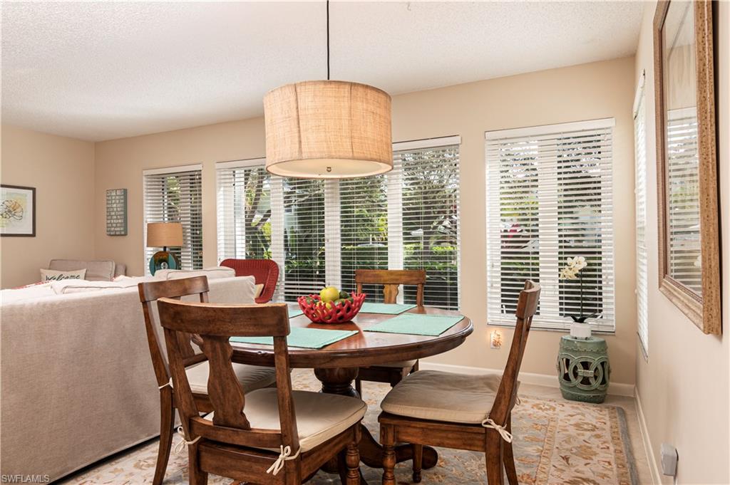 284 4th Street South, Unit 103 Naples, FL 34102 - Photo 5 of 11 a dining room with furniture a chandelier and wooden floor