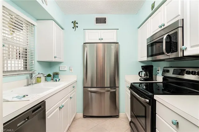 a kitchen with stainless steel appliances a refrigerator sink and microwave