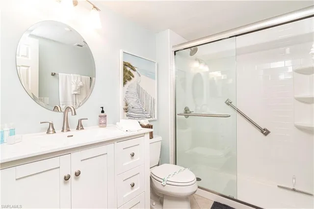 a bathroom with a shower sink vanity mirror and toilet