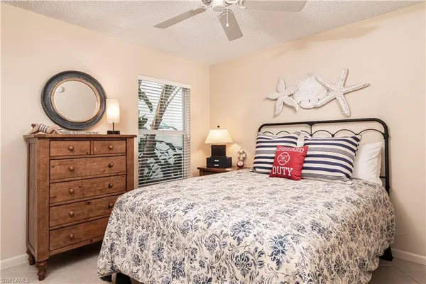 a bedroom with a bed a dresser and mirror