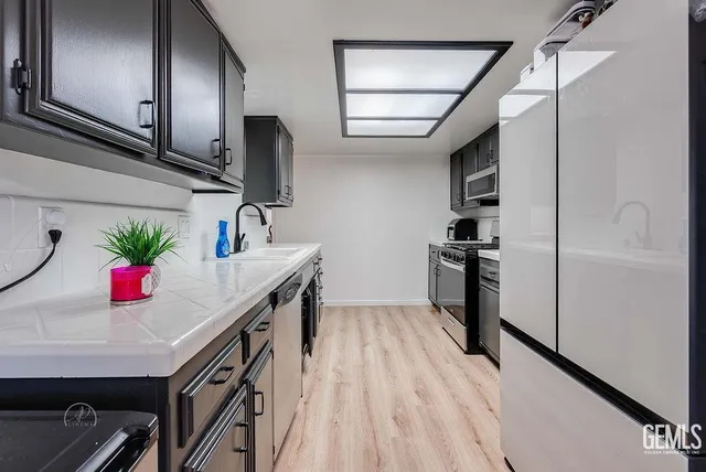 a kitchen with granite countertop a sink stainless steel appliances a counter space and cabinets