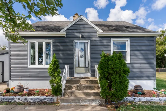 a front view of a house with plants