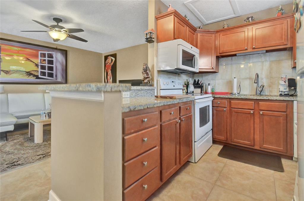 33 Fanshaw A, Unit 33 Boca Raton, FL 33434 - Photo 7 of 16 a kitchen with stainless steel appliances granite countertop a sink and cabinets