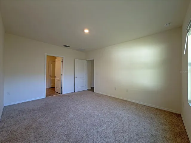 an empty room with an entryway and fan