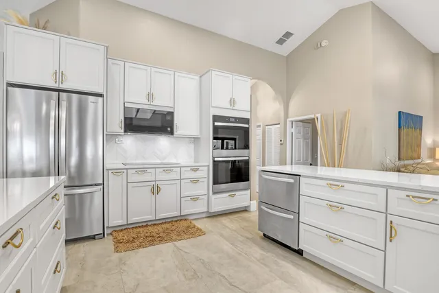 a kitchen with stainless steel appliances granite countertop a sink and a refrigerator