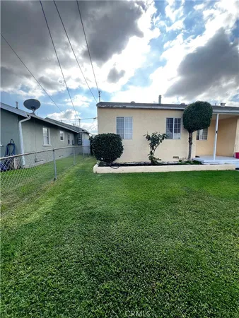 a view of a house with a yard and a large tree