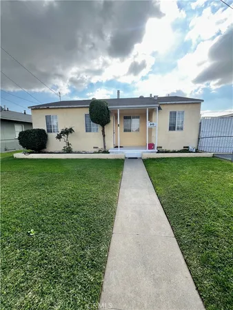 a view of a yard in front of a house with a large tree
