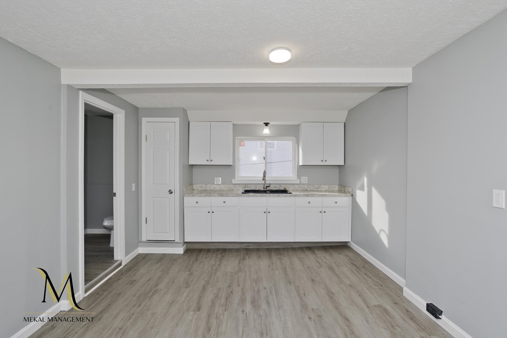 a large white kitchen with sink and refrigerator