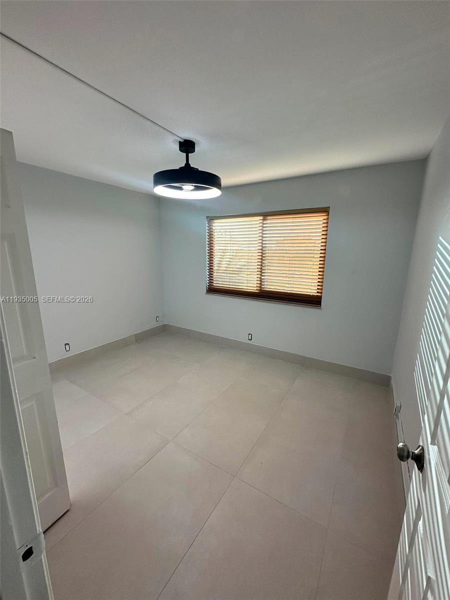 9440 Southwest 8th Street, Unit 402 Boca Raton, FL 33428 - Photo 42 of 45 an empty room with windows and fan