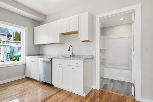a kitchen with granite countertop white cabinets and white appliances