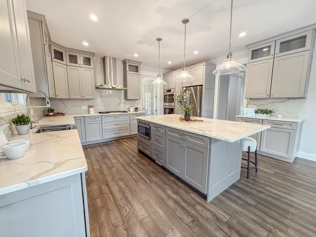 a large kitchen with kitchen island a sink a center island stainless steel appliances and a center island