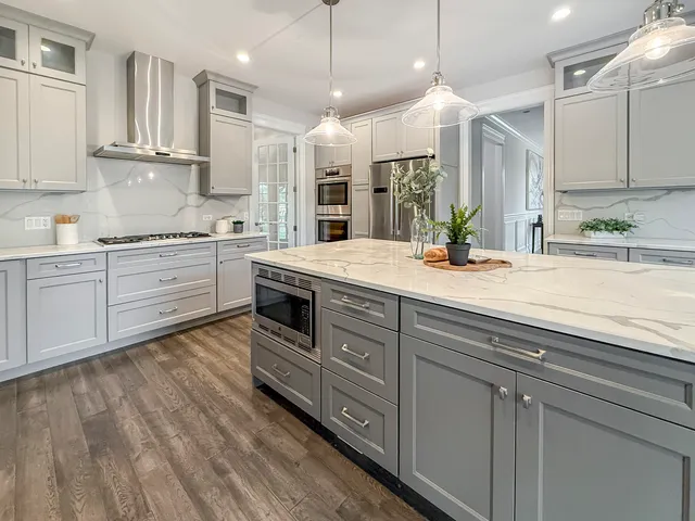 a kitchen with stainless steel appliances granite countertop a sink a stove and cabinets