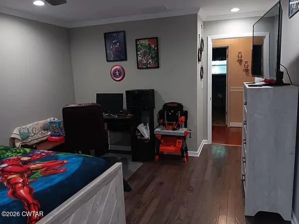 a bedroom with bed and wooden floor