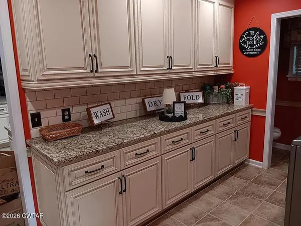 a kitchen with granite countertop white cabinets and sink