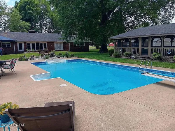 a view of outdoor space with swimming pool and trees