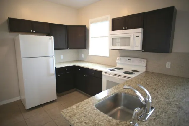 a kitchen with stainless steel appliances granite countertop a stove and a refrigerator