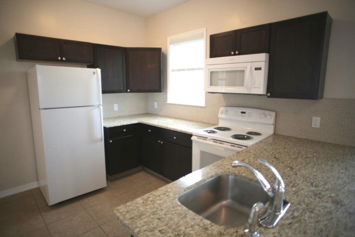 78 Riberia Street St. Augustine, FL 32084 - Photo 11 of 38 a kitchen with a sink and a refrigerator