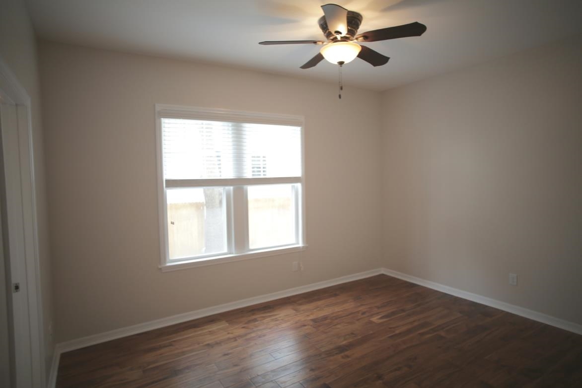 78 Riberia Street St. Augustine, FL 32084 - Photo 16 of 38 an empty room with wooden floor ceiling fan and windows