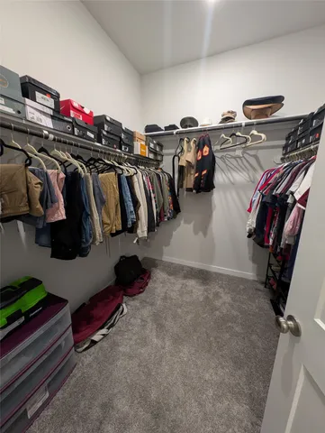 a view of walk in closet with clothes and shoes