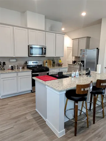 a kitchen with a sink a microwave and cabinets