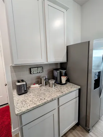 a kitchen with granite countertop cabinets and refrigerator