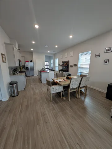 a view of a dining room with furniture a rug and wooden floor