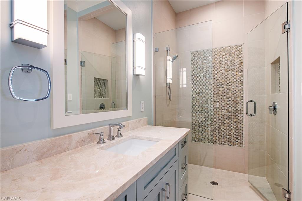7100 Verde Way Naples, FL 34108 - Photo 13 of 18 a bathroom with a granite countertop sink a mirror a shower and a bathtub