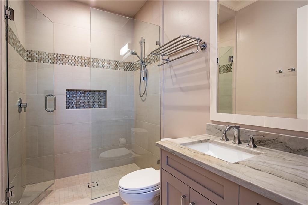 7100 Verde Way Naples, FL 34108 - Photo 16 of 18 a bathroom with a granite countertop sink a mirror and a shower