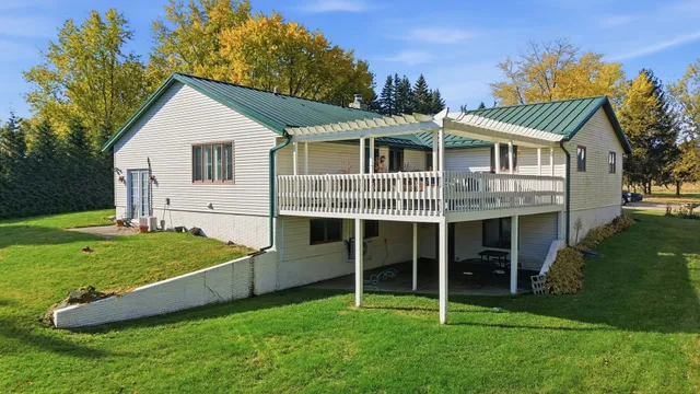 a view of a wooden deck with grass and a yard