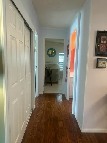 a view of a hallway with wooden floor stairs and a livingroom