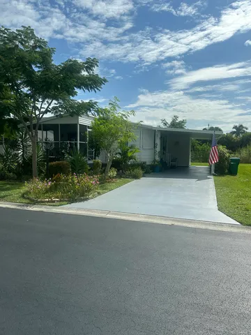 a view of a house with a yard and potted plants