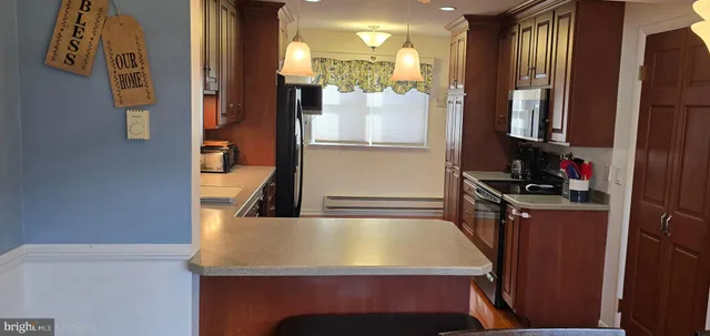 a room with kitchen island a counter top space and stainless steel appliances