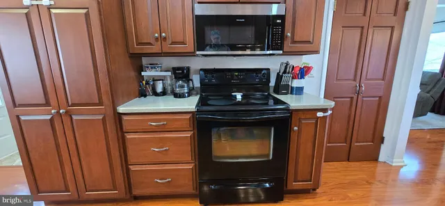 a kitchen with stainless steel appliances wooden cabinets and a stove top oven