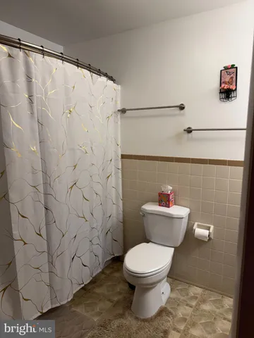 a bathroom with a toilet and a shower curtain