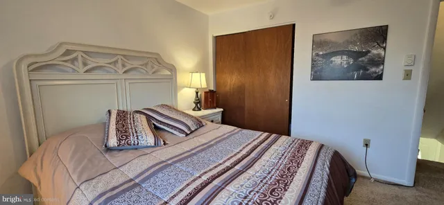 a bedroom with a bed and a flat tv screen on dresser