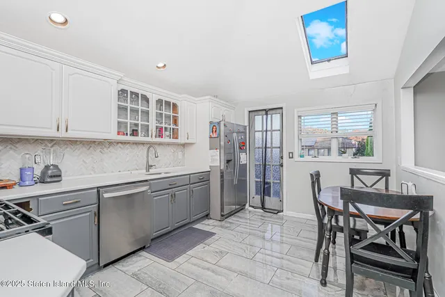 a kitchen with stainless steel appliances granite countertop a stove top oven a sink dishwasher and a refrigerator with wooden cabinets